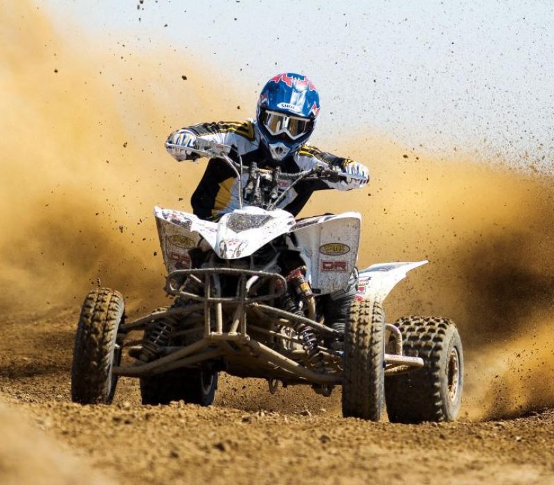 man riding white four wheeler on dirt